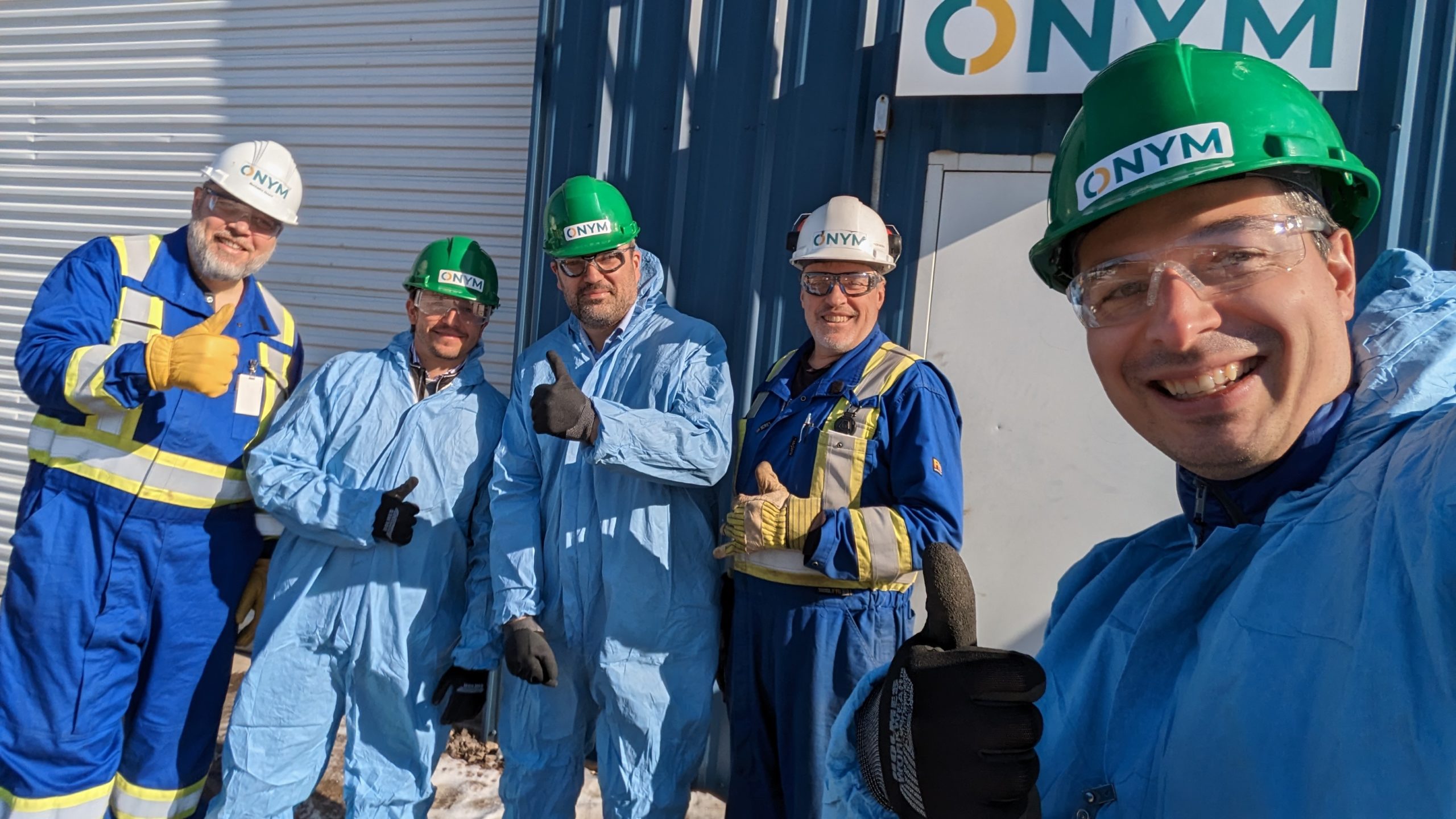 Bioenergy, Groupe Onym receives $10000 five men with protective clothing in front of the technological showcase of the Onym Group